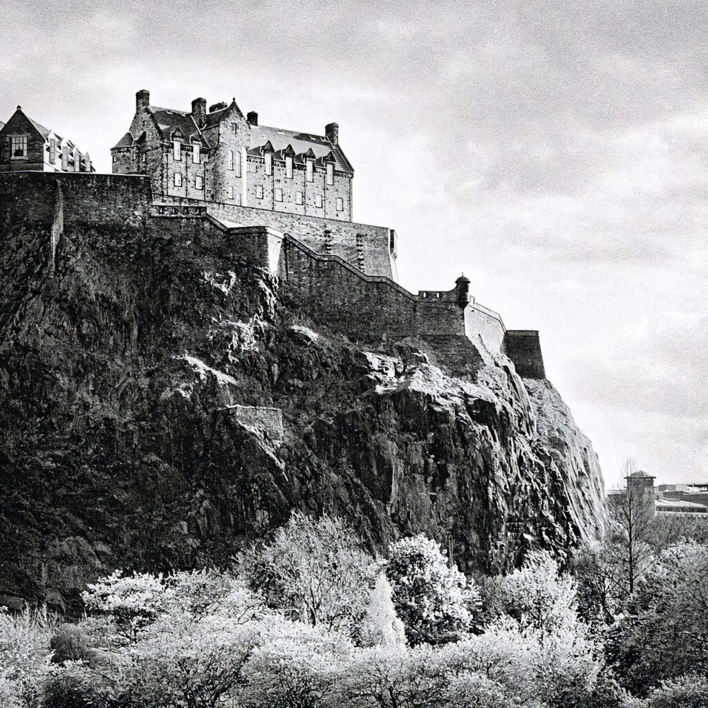 Black and white Edinburgh Castle on rugged cliffs with historic walls and soft clouds background Wallpaper
