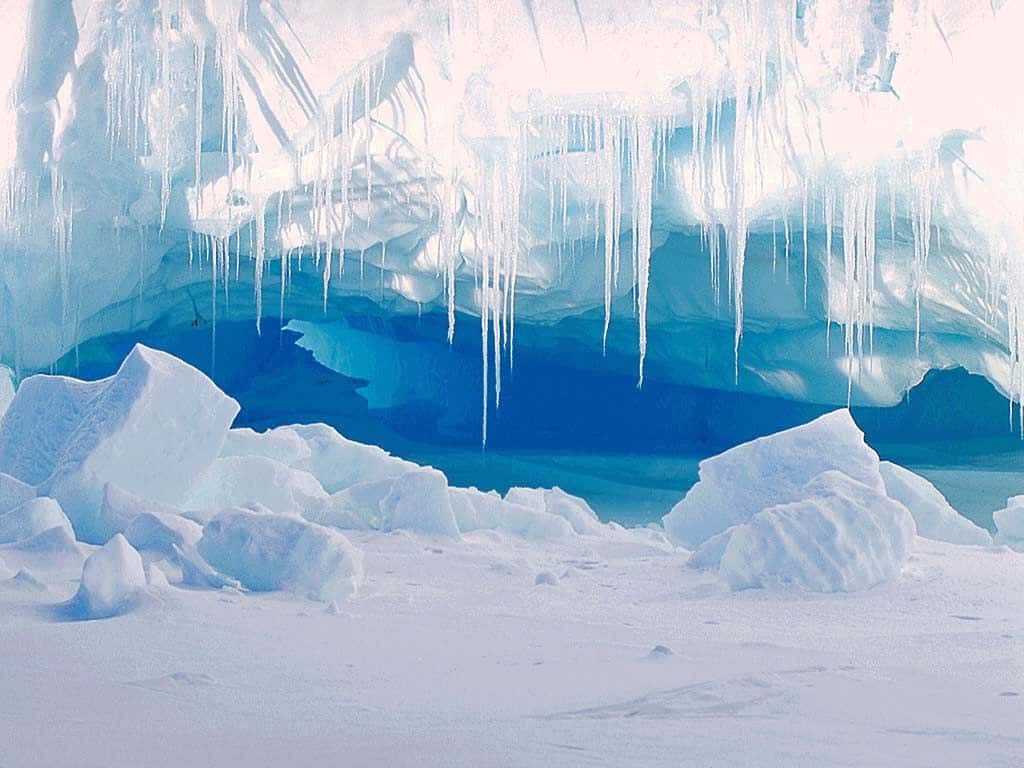 Majestic glacial cavern with sharp icicles and vivid deep blue ice in high-resolution wallpaper