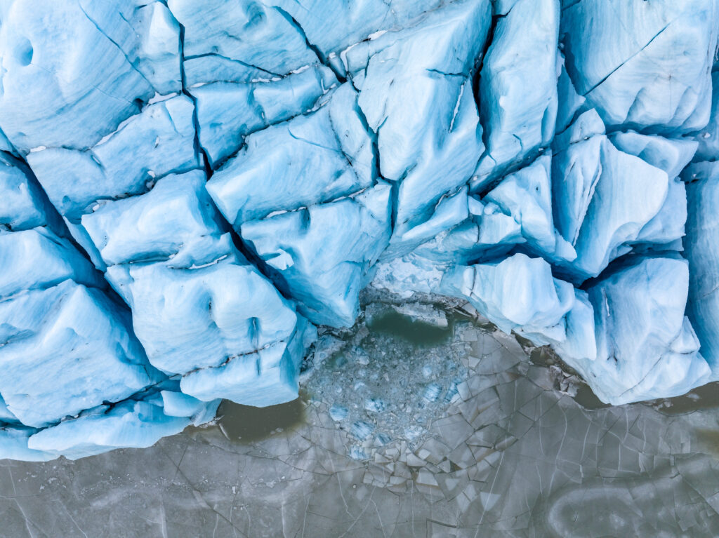 Glacier wallpaper showing intricate ice formations deep blue hues rugged cracks and snow-covered reliefs