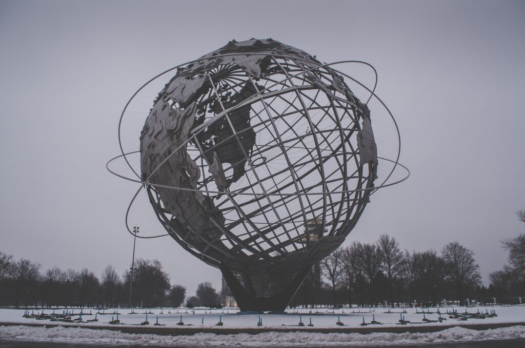 Majestic Globe Sculpture Wallpaper with Snowy Sky & Barren Trees