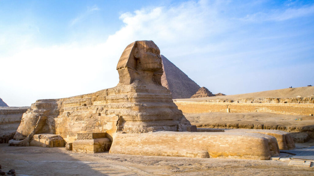Majestic Great Sphinx Side View Wallpaper with Pyramid Background