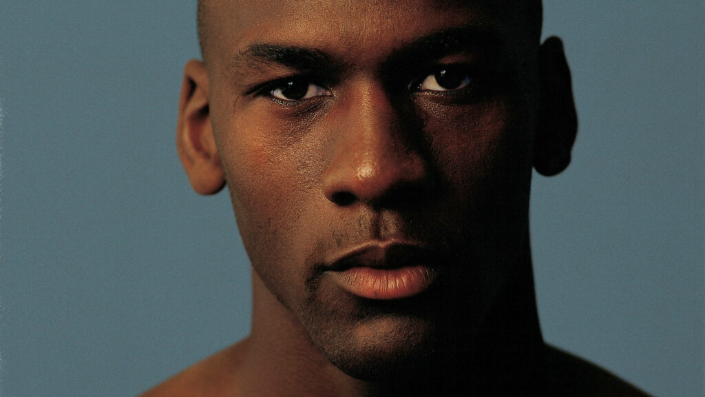 The Mesmerizing Gaze of Michael Jordan: An Iconic Close-Up Portrait in Moody Blue Wallpaper