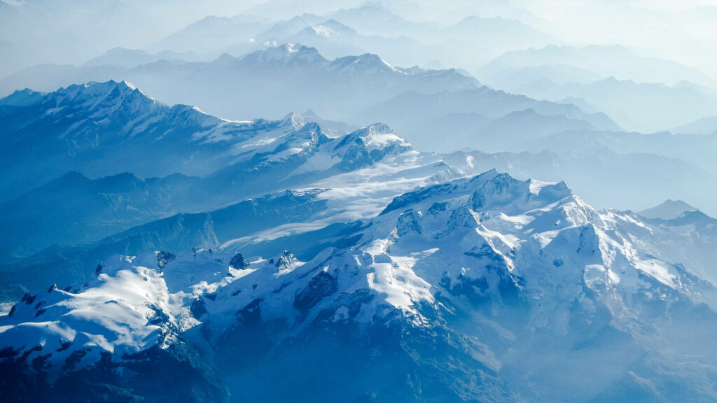 Misty Winter Wonderland: Majestic Snowy Mountains as a Breathtaking Aesthetic Wall Art Wallpaper
