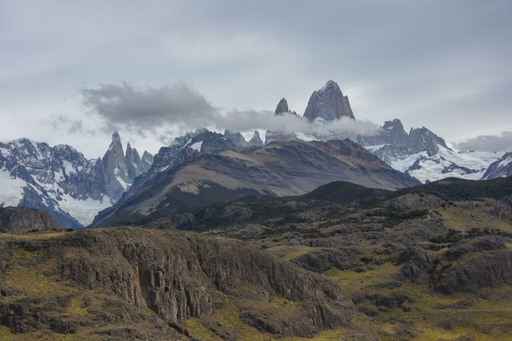 Dramatic mountain landscape with rugged peaks snowy summits and drifting clouds wallpaper background