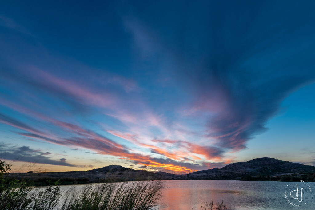 Majestic mountains reflected in a calm lake with vibrant sunset clouds serene landscape wallpaper