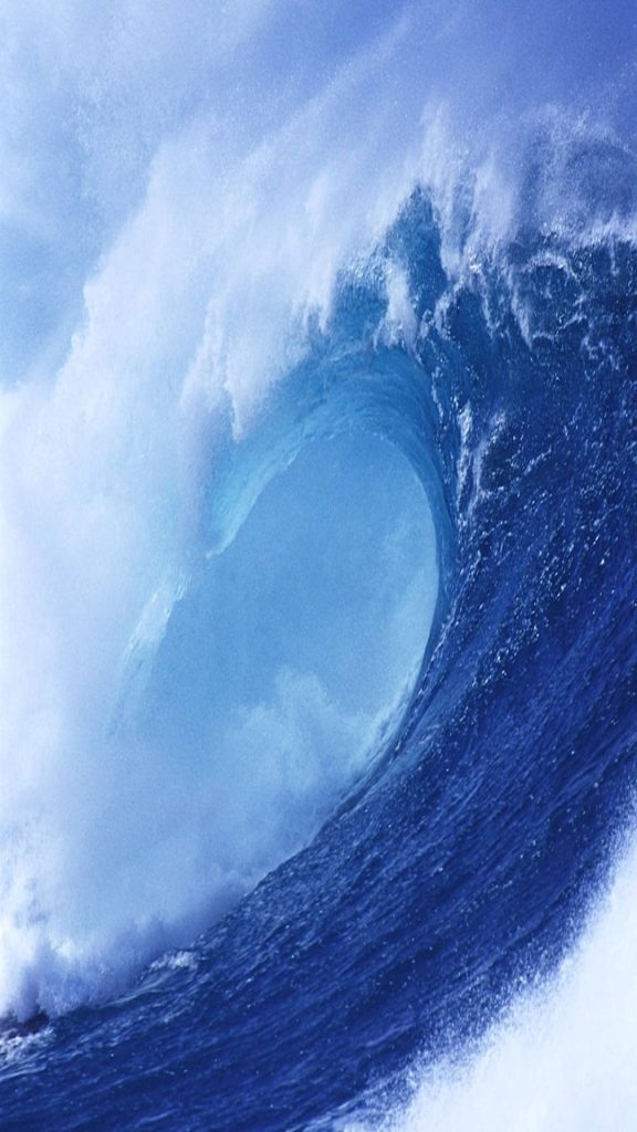 Majestic translucent blue ocean wave crashing with vibrant cyan tones and dynamic sea foam Wallpaper