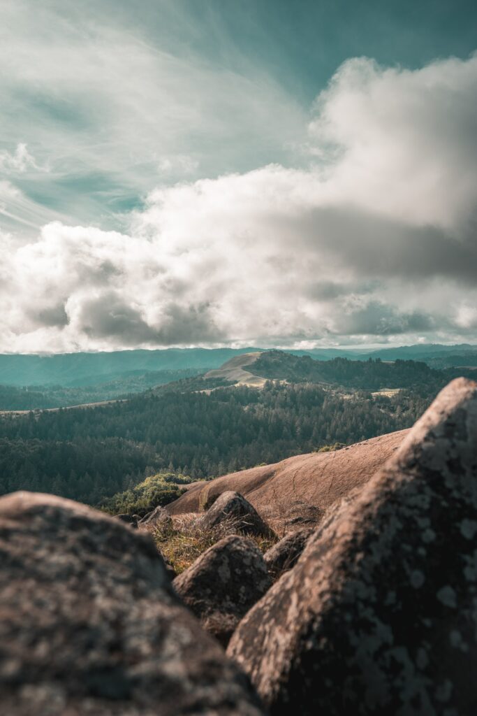 Rugged mountain landscape with large stones under dramatic clouds and soft natural light Wallpaper