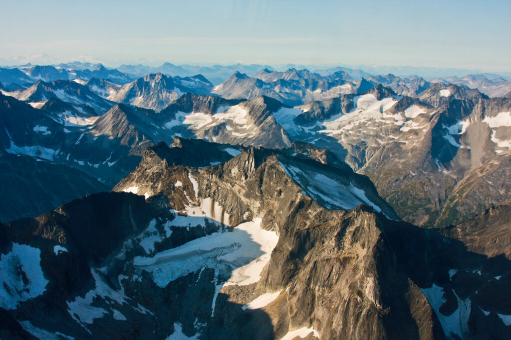 Snow-capped rugged mountain peaks and expansive snowy slopes in a vast alpine landscape wallpaper