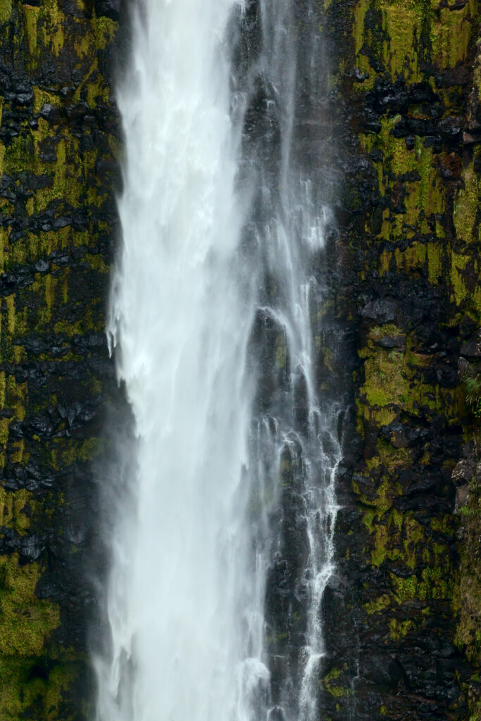 Waterfall crashing over mossy rocks with white splashes and mist nature wallpaper background