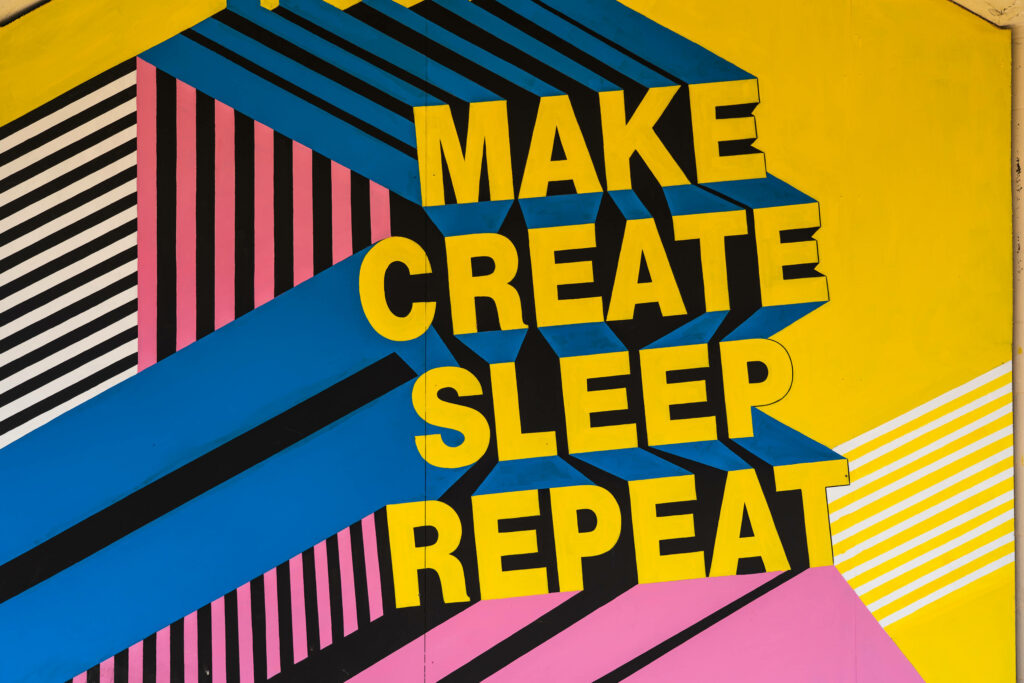 Vibrant pop art wallpaper with Make Create Sleep Repeat in bold yellow on colorful geometric background