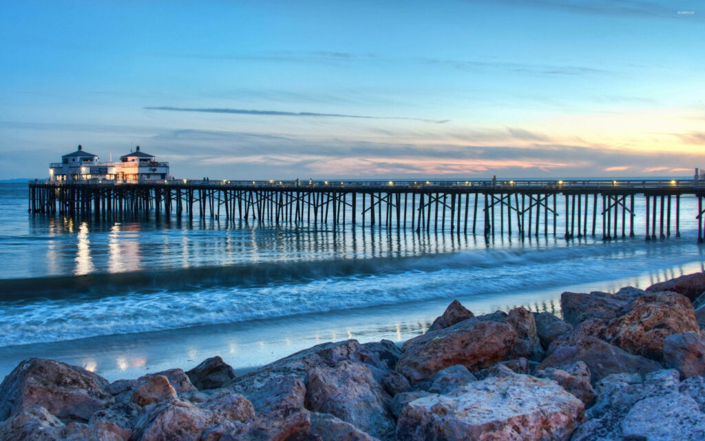 A Captivating View of Malibu Pier: A Cool-Tinted Wallpaper from the Rocky Malibu Beach