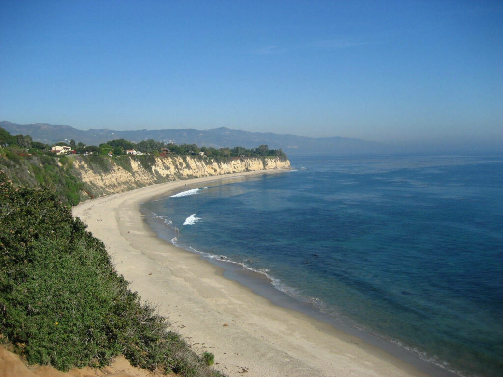 Serene Malibu Beach: Captivating Aerial View of Pristine Sands and Deep Blue Ocean Wallpaper