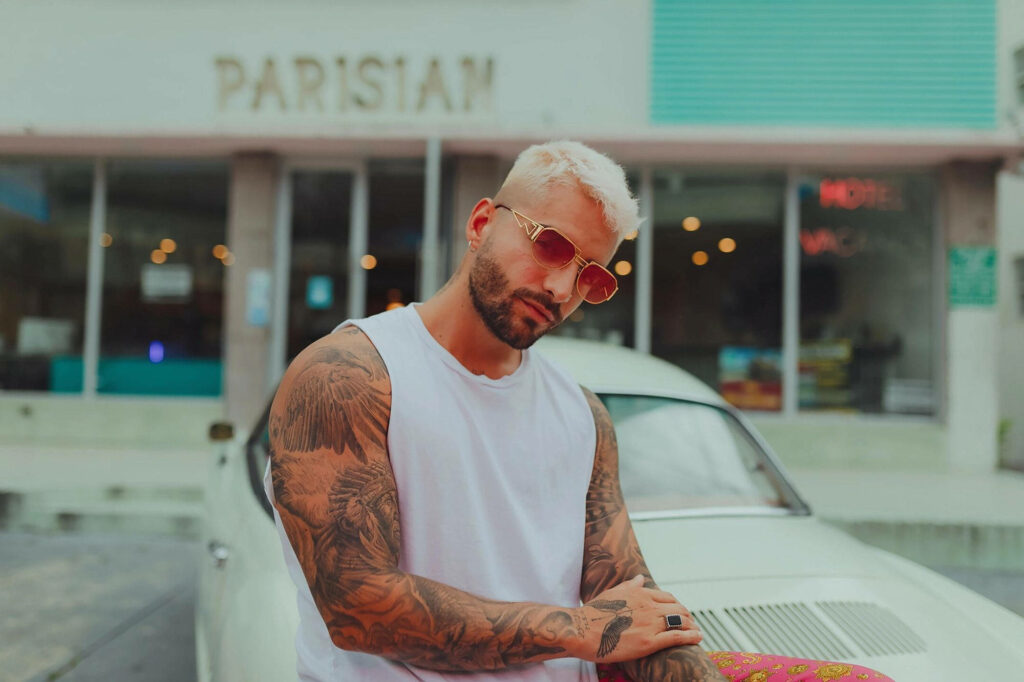 Maluma posing with tattoos and stylish look beside retro car Paris sign Papi Juancho era wallpaper