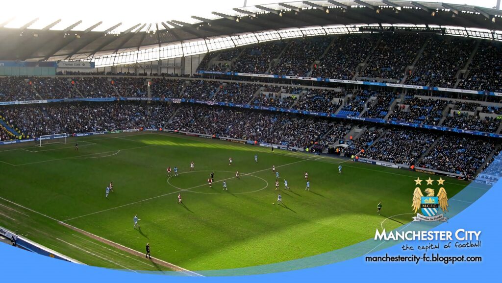 Manchester City FC logo over Etihad Stadium packed with fans during a live match wallpaper