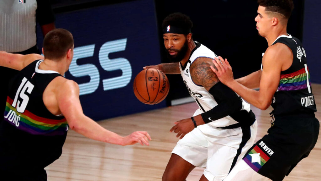 Marcus Morris driving past Denver Nuggets defenders intense NBA action Los Angeles Clippers wallpaper