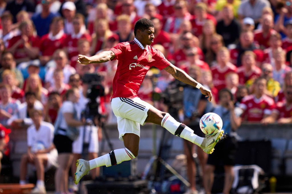 Marcus Rashford mid-air striking soccer ball dynamic Manchester United action wallpaper