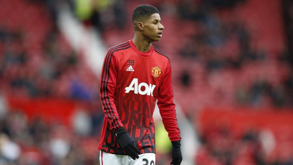 Marcus Rashford in red Aon training jersey intense on pitch Manchester United sports wallpaper