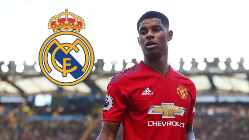 Marcus Rashford in Manchester United kit with Real Madrid crest blurred stadium background wallpaper