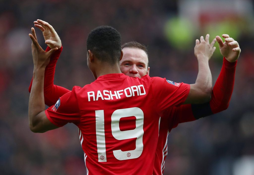 Marcus Rashford and Wayne Rooney celebrating a goal in red Manchester United kits wallpaper background