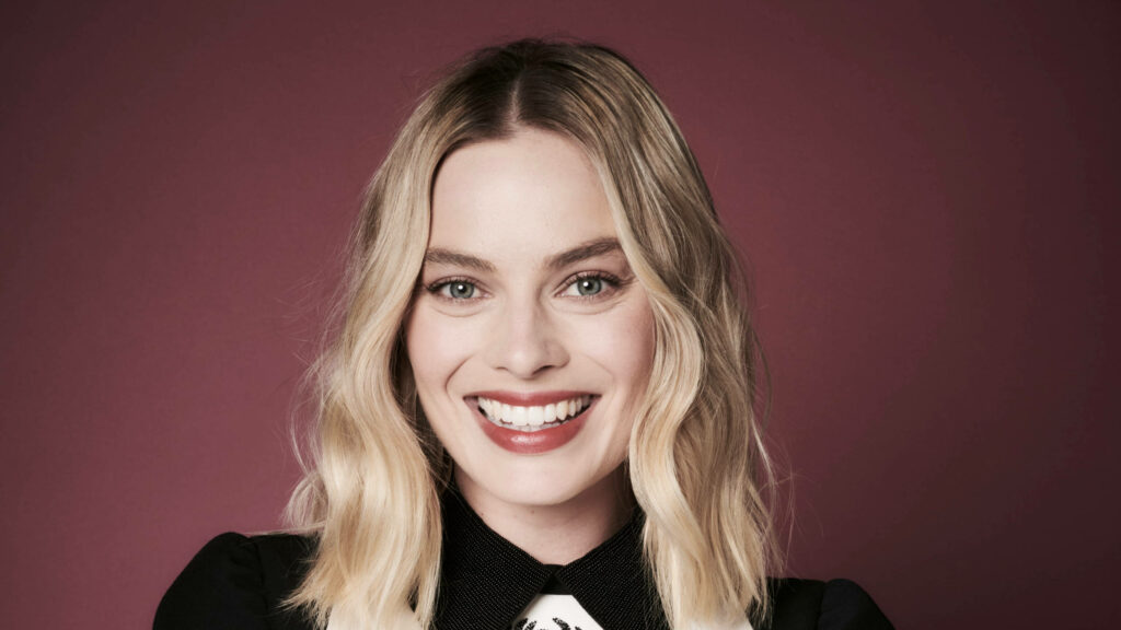 Margot Robbie bright smile cheerful portrait warm confident woman against soft burgundy background Wallpaper