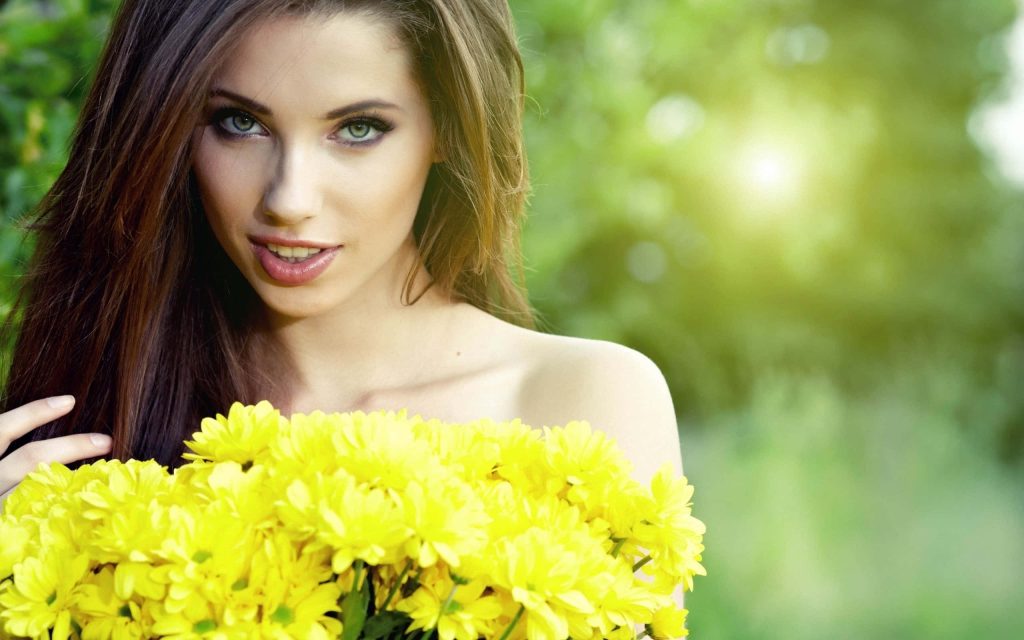 Model Marika with vibrant yellow chrysanthemums in sunlit garden showcasing spring beauty Wallpaper