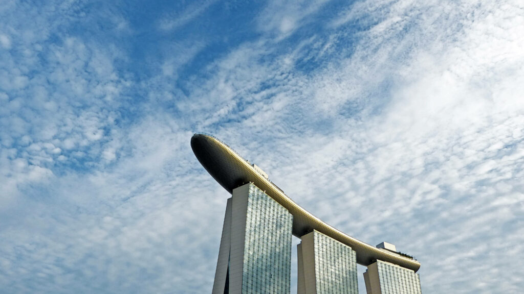 Marina Bay Sands skyline wallpaper with futuristic glass towers and dramatic blue cloud sky background