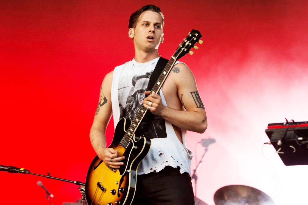 Mark Foster of Foster the People playing hollow-body guitar vibrant red concert wallpaper background