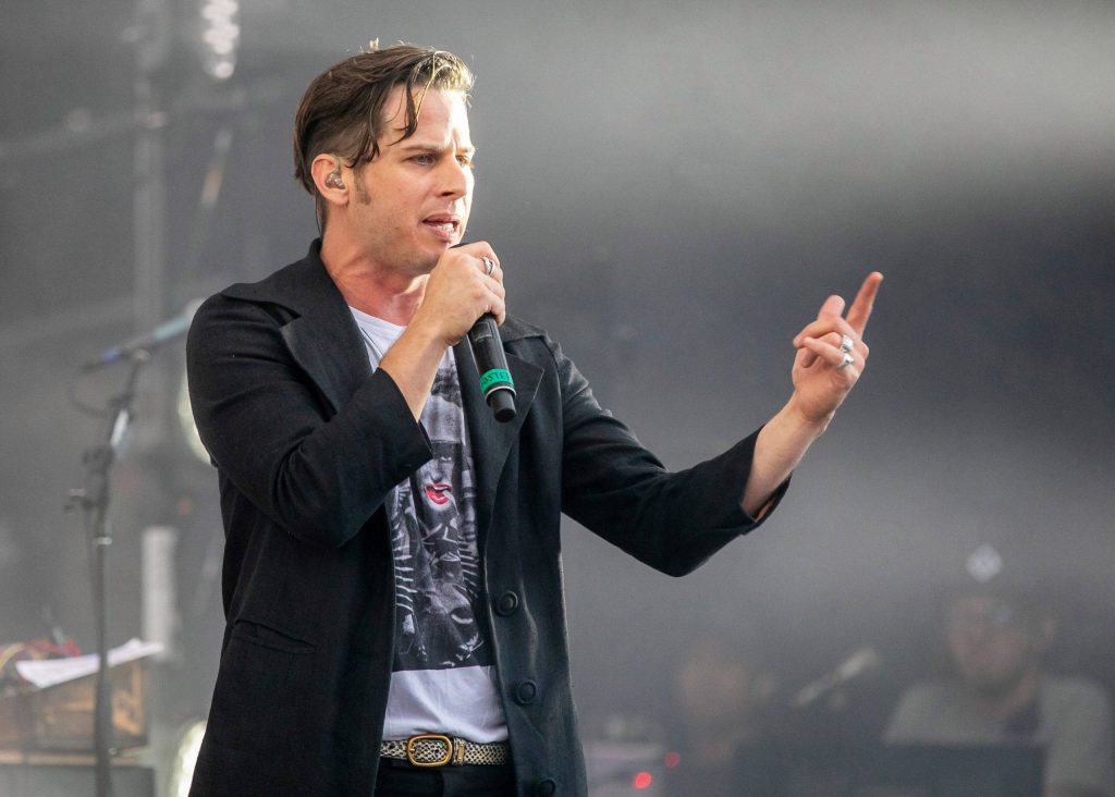 Mark Foster lead singer Foster the People mid performance expressive gestures concert wallpaper