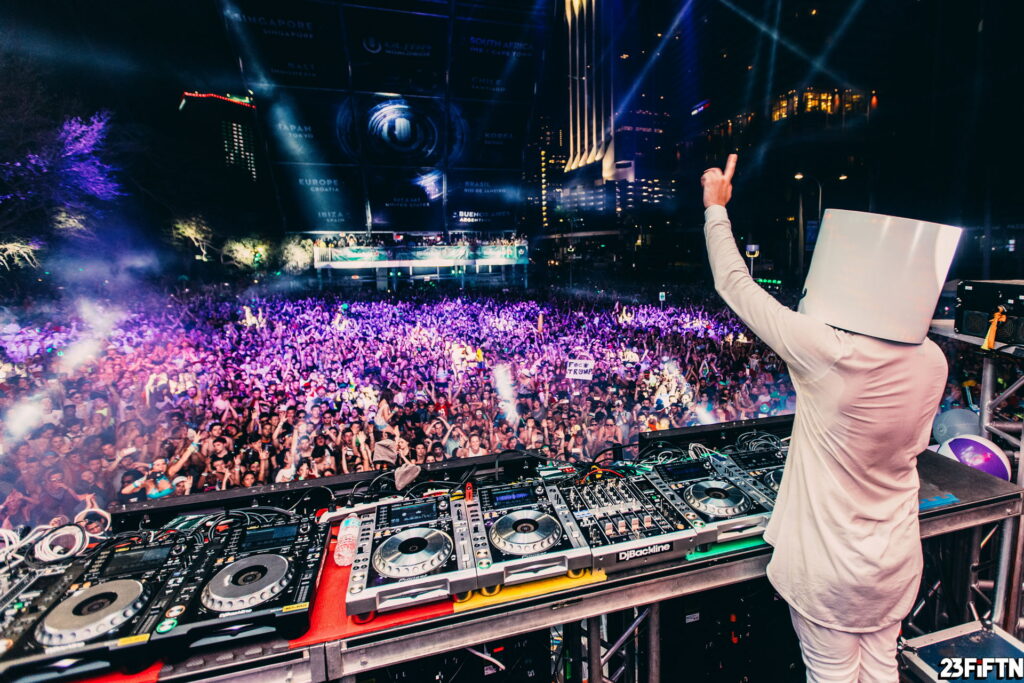 Marshmello DJ performing live at Ultra Music Festival with vibrant purple stage lights crowd dancing Wallpaper
