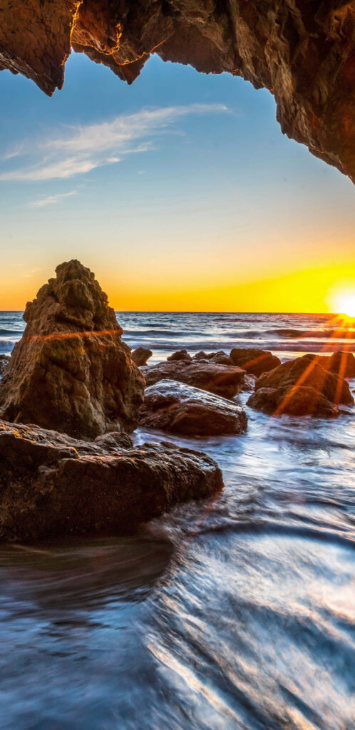Mesmerizing Malibu: Captivating Cave View with Rocky Water's Surface Wallpaper