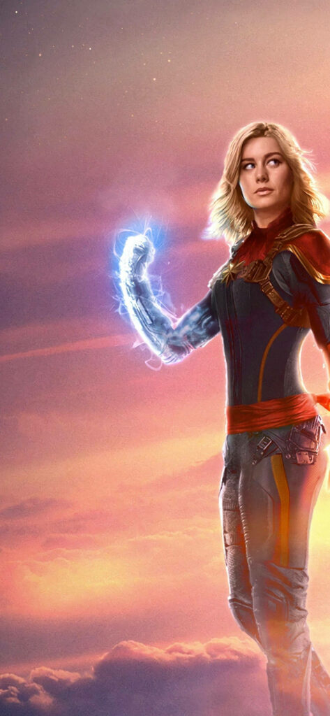 Gorgeous Captain Marvel Poses Triumphantly amidst Pastel Sky: A Captivating Superhero Wallpaper for iPhone