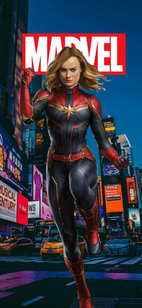 Nighttime Marvel: Carol Danvers Strikes a Superhero Pose amidst the Cityscape in Alluring iPhone Graphic Artwork Wallpaper