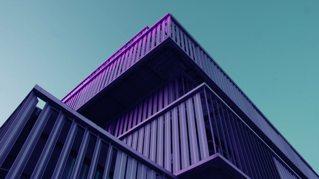 Steel Symphony: Magnificent Purple Façade Captured in 4k Architecture Wallpaper Beneath a Serene Blue Sky