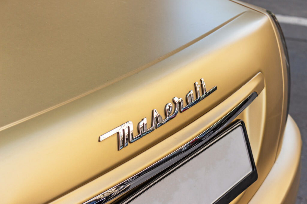 Maserati Emblem Wallpaper: Luxurious Golden Matte Background