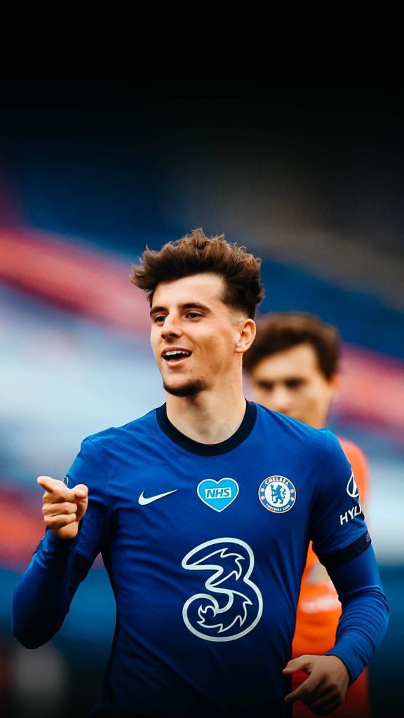 Cheerful Mason Mount in Chelsea FC blue kit with NHS and 3 logos on pitch wallpaper background