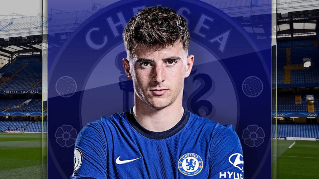 Chelsea Mason Mount in blue kit with crest and blurred stadium background wallpaper