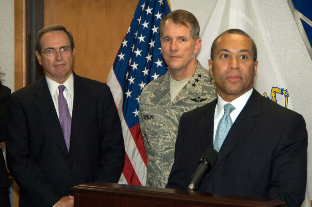 Massachusetts Governor Deval Patrick with officials at podium during government press event with flags Wallpaper