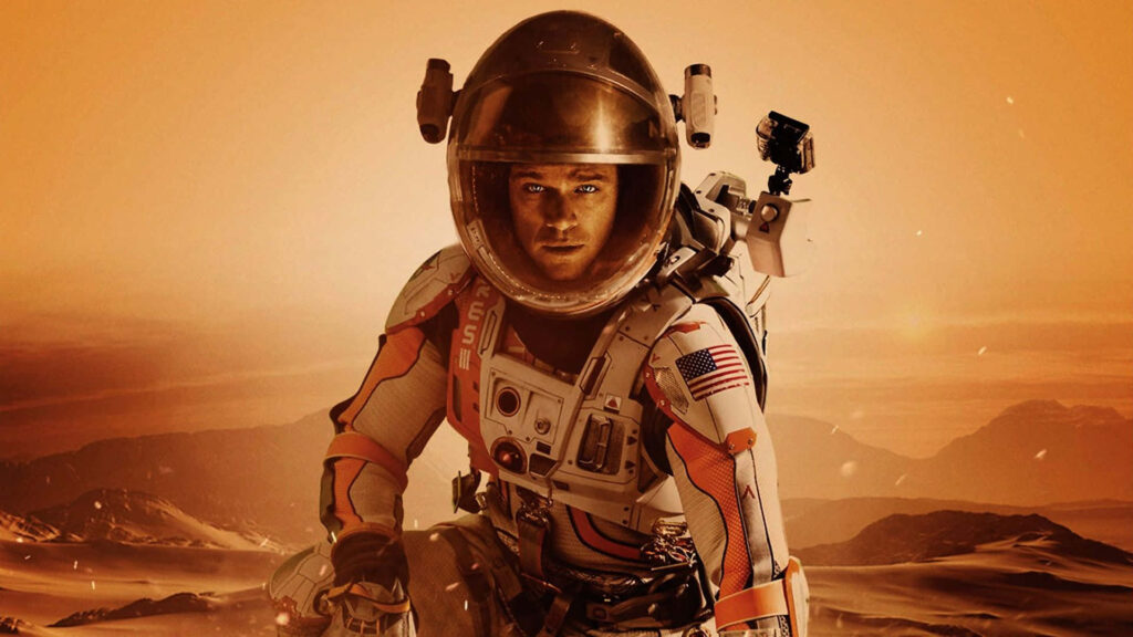 Matt Damon as Mark Watney in spacesuit on rugged orange Martian surface from The Martian wallpaper