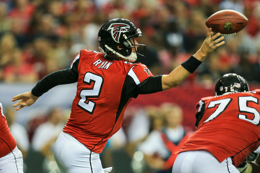 Atlanta Falcons quarterback Matt Ryan mid-throw focused during intense football game action wallpaper