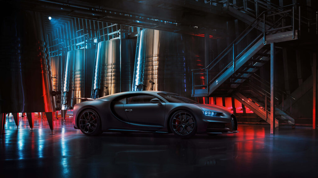 Sleek matte black Bugatti in futuristic industrial setting with blue and red neon lights background Wallpaper