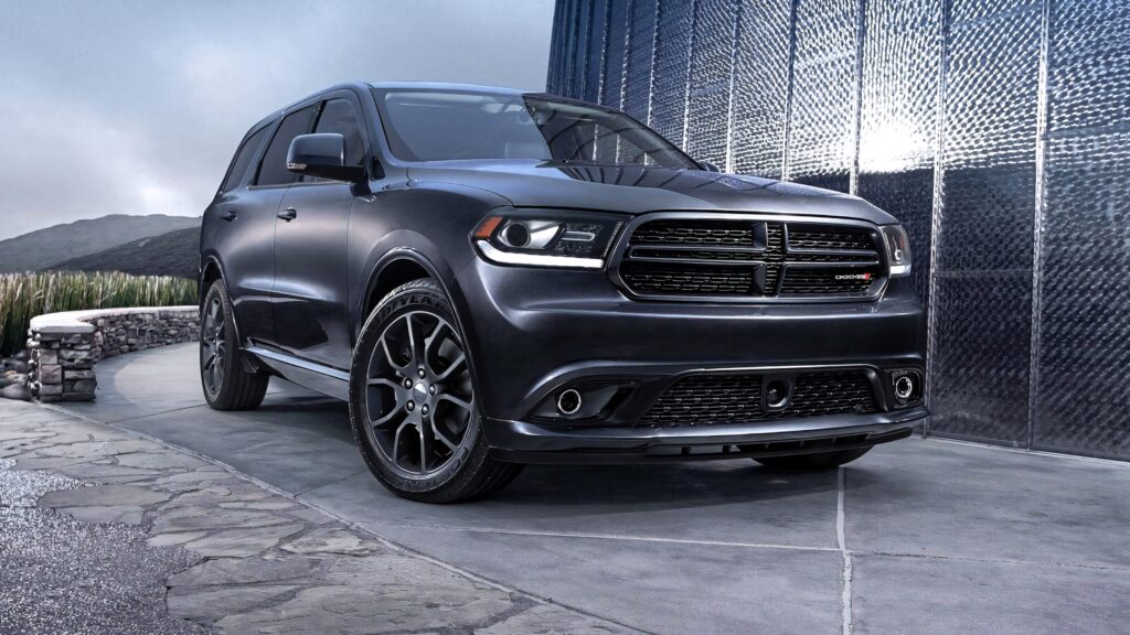Matte black Dodge Durango on modern driveway with bold grille sleek lines urban backdrop Wallpaper
