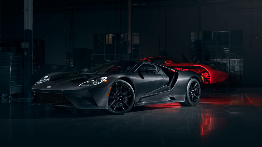 Matte black Ford GT in dimly lit garage showcasing aggressive lines and sporty design wallpaper