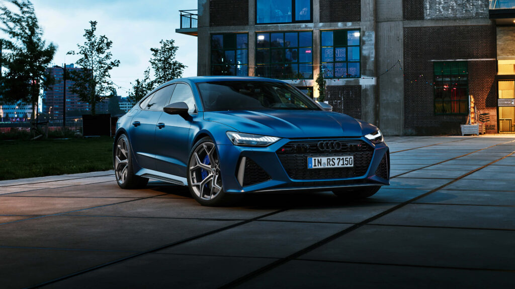 Matte blue Audi RS7 parked in urban dusk highlighting bold grille and dynamic design elements Wallpaper