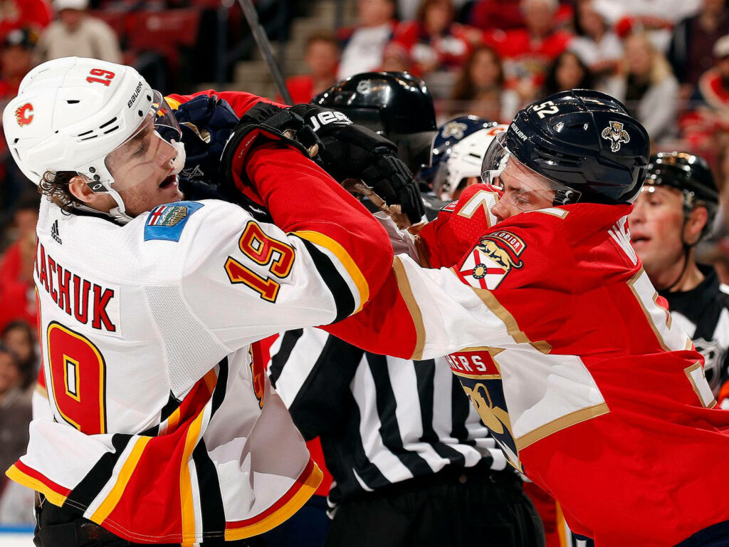 Matthew Tkachuk in Calgary Flames jersey in intense hockey game action with bold red white colors Wallpaper