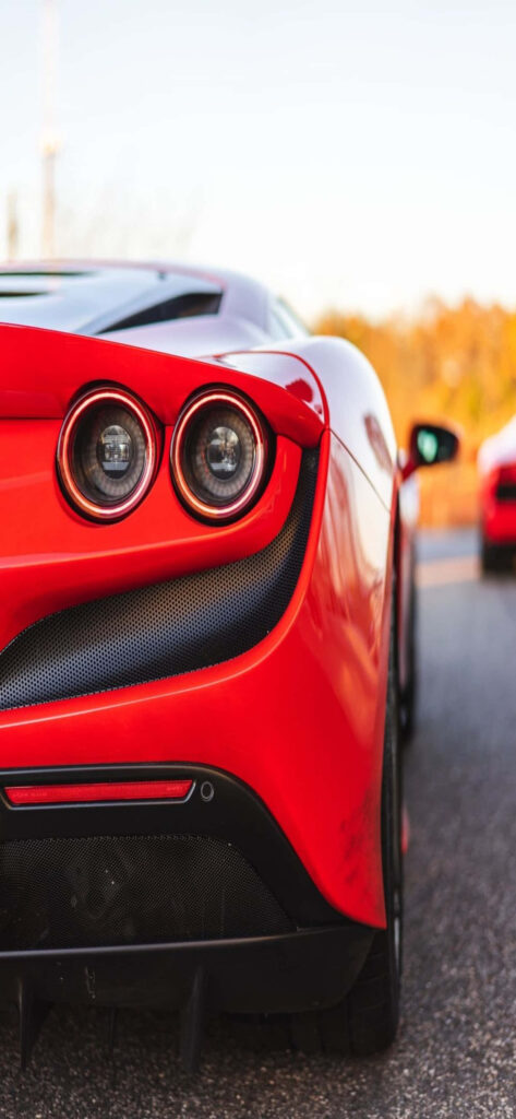 Exhilarating Max Ferrari Backdrop with Striking Red Ferrari F8 Tributo Amidst Dynamic Background Wallpaper