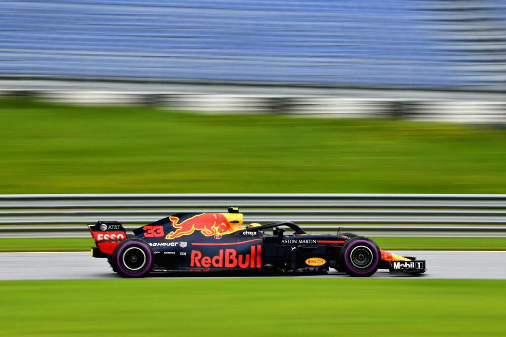 Max Verstappen driving Red Bull RB14 Formula 1 race car on track with blurred motion background Wallpaper