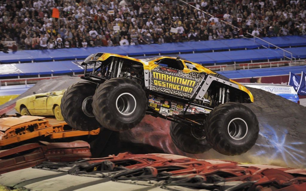 Maximum Destruction monster truck in mid-air over crushed cars at Monster Jam arena action shot Wallpaper