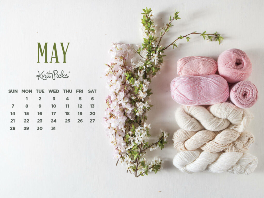May 2022 calendar wallpaper with pastel pink white flowers and blush cream yarn for crafters