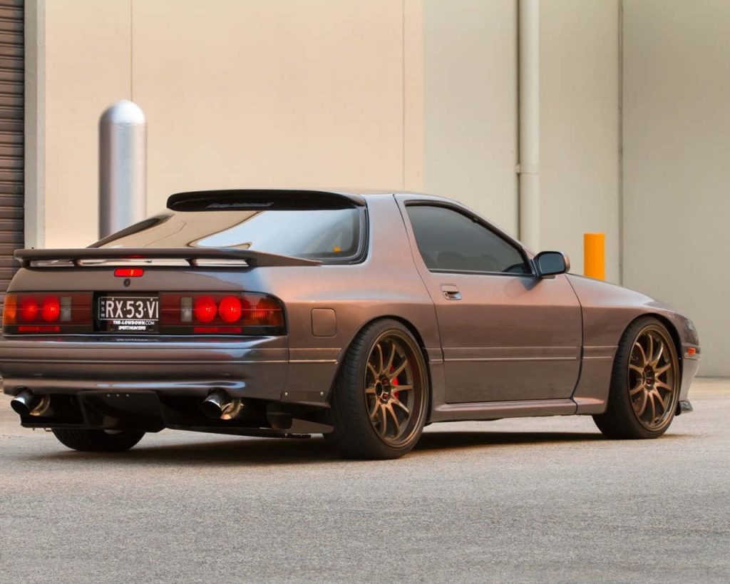 Modified Mazda RX-7 FC Havana Brown rear view with bronze wheels industrial background wallpaper