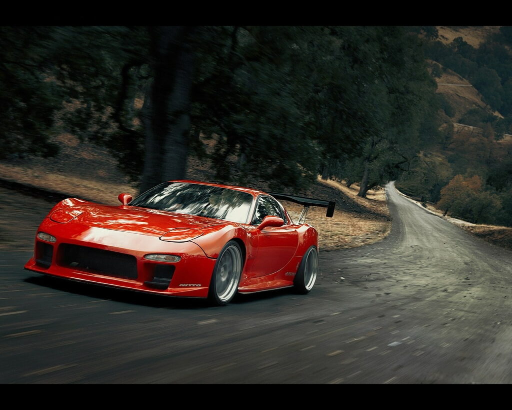 Revved up in the Enchanted Woods: A Majestic Mazda RX7 Roars through the Serene Forest Wallpaper